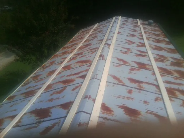 Rusted metal roof panels with new wood purlins before replacement — Storm Damage Roof Repair in Calvin by Roofing Brothers