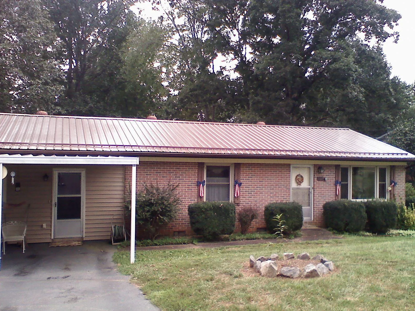 Bronze metal roof and carport on a brick ranch home — Roof Repair work by our crew in Calvin